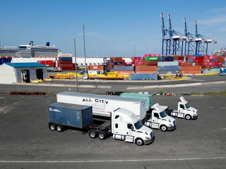 Three All City Leasing trucks parked at a shipping terminal with cargo containers and cranes in the background