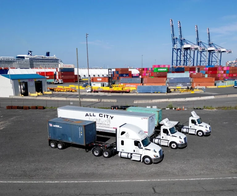 Three All City white semi trucks parked at container shipping terminal in Newark NJ, ready for port drayage, freight transport, and logistics services